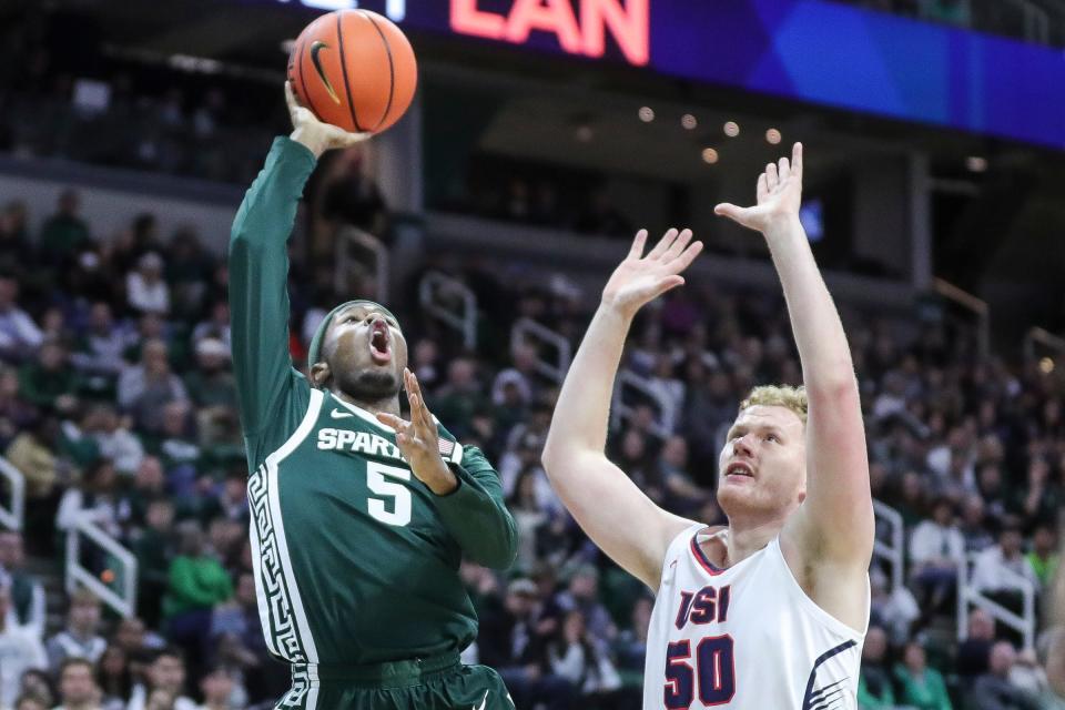 Michigan State guard Tre Holloman (5) makes a layup against Southern Indiana forward Nick Hittle (50) during the first half at Breslin Center in East Lansing on Thursday, Nov. 9, 2023.