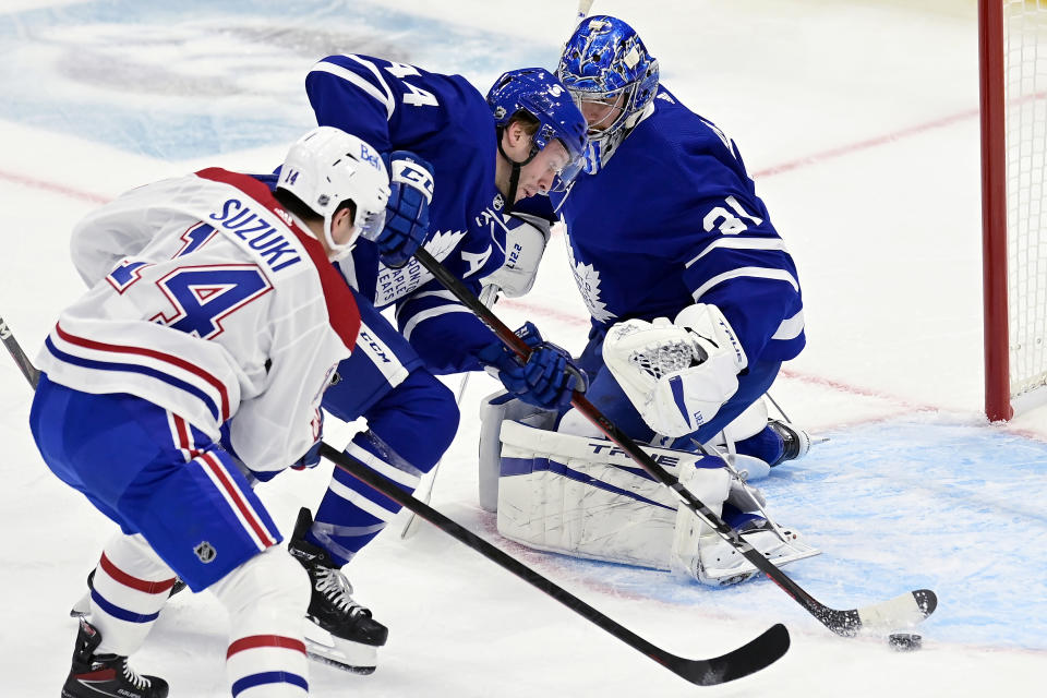 Toronto Maple Leafs defenseman Morgan Rielly (44) moves the puck away from goalie Frederik Andersen (31) as Montreal Canadiens center Nick Suzuki (14) pressures during the first period of an NHL hockey game in Toronto, Wednesday, Jan. 13, 2021. (Frank Gunn/The Canadian Press via AP)