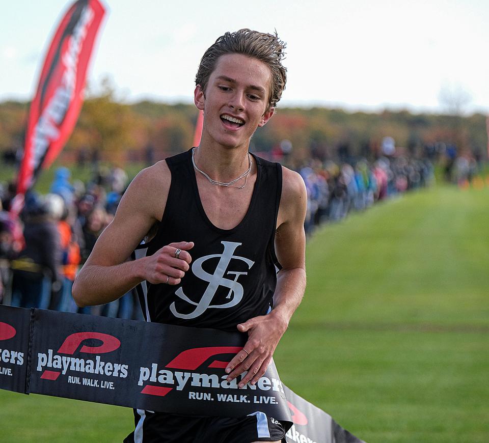 Joey Bowman (305) from St. Johns is all smiles as he finishes in first place at the Greater Lansing Cross Country meet Saturday, Oct. 15, 2022. 