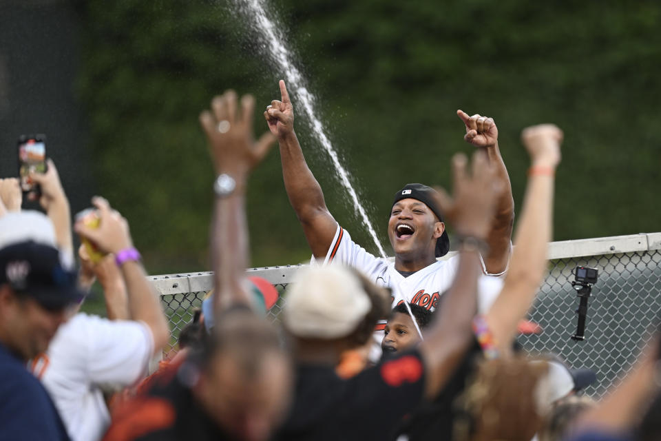 Maryland Gov. Wes Moore and son James spray fans with a hose in the bird bath during the third inning of a baseball game between the Baltimore Orioles and New York Yankees, Sunday, July 30, 2023, in Baltimore.(AP Photo/Gail Burton)