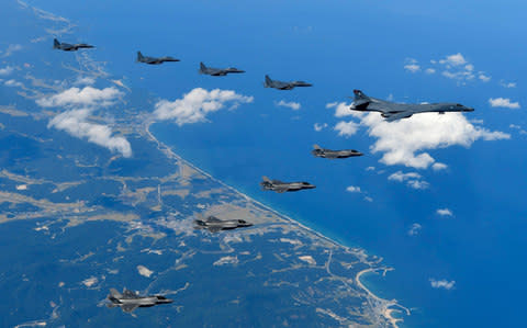South Korean F-15K combat planes (top, L), a U.S. Air Force B-1B bomber plane (C-R) and F-35B combat planes (bottom, L) fly over South Korea - Credit: South Korea Defense Ministry