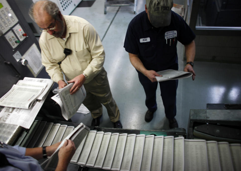 FILE - Workers check over the final edition of the Rocky Mountain News in the Washington Street Printing Plant of the Denver Newspaper Agency in Denver on Thursday, Feb. 26, 2009. The paper's final issue date was Feb. 27, 2009. The decline of local news in the United States is speeding up despite attention paid to the issue, to the point where the nation has lost one-third of its newspapers and two-thirds of its newspaper journalists since 2005. (AP Photo/David Zalubowski, File)