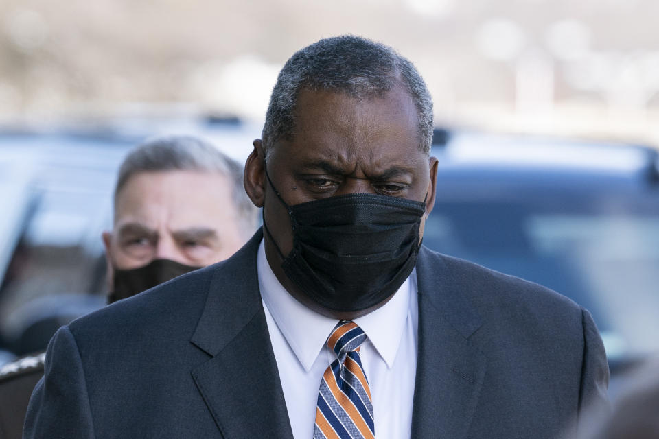 Defense Secretary Lloyd Austin arrives at the Pentagon, followed by Joint Chiefs Chairman Gen. Mark Milley, Friday, Jan. 22, 2021, in Washington. (AP Photo/Alex Brandon)