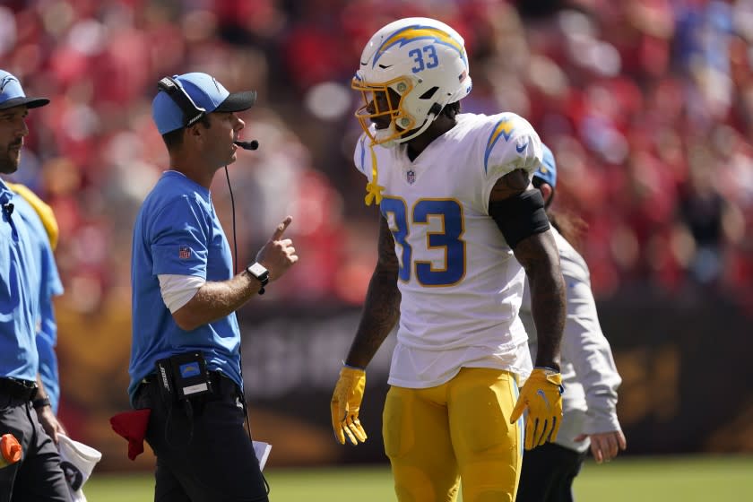 Los Angeles Chargers head coach Brandon Staley talks with Derwin James (33) during the first half of an NFL football game against the Kansas City Chiefs, Sunday, Sept. 26, 2021, in Kansas City, Mo. (AP Photo/Charlie Riedel)