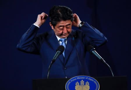 Japan's Prime Minister Shinzo Abe adjusts his headphones during a news conference at a hotel in London, Britain April 29, 2017. REUTERS/Peter Nicholls