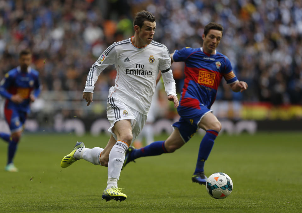 Real Madrid's Gareth Bale, left, in action with Elche's Edu Albacar, right, during a Spanish La Liga soccer match between Real Madrid and Elche at the Santiago Bernabeu stadium in Madrid, Spain, Saturday, Feb. 22, 2014. (AP Photo/Andres Kudacki)