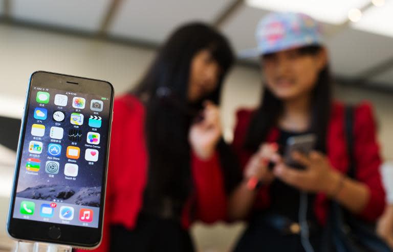 Chinese girls check out the iPhone 6 in an Apple store in Shanghai on October 17, 2014