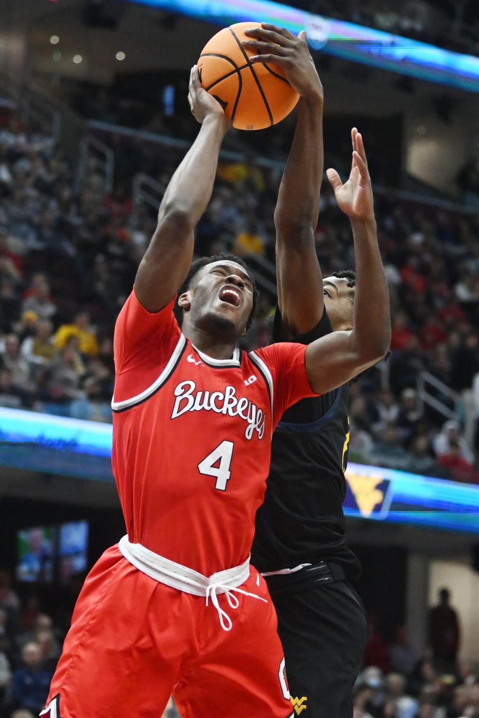 Dec 30, 2023; Cleveland, Ohio, USA; Ohio State Buckeyes guard Dale Bonner (4) and West Virginia Mountaineers guard Kobe Johnson (2) go for a rebound during the first half at Rocket Mortgage FieldHouse. Mandatory Credit: Ken Blaze-USA TODAY Sports