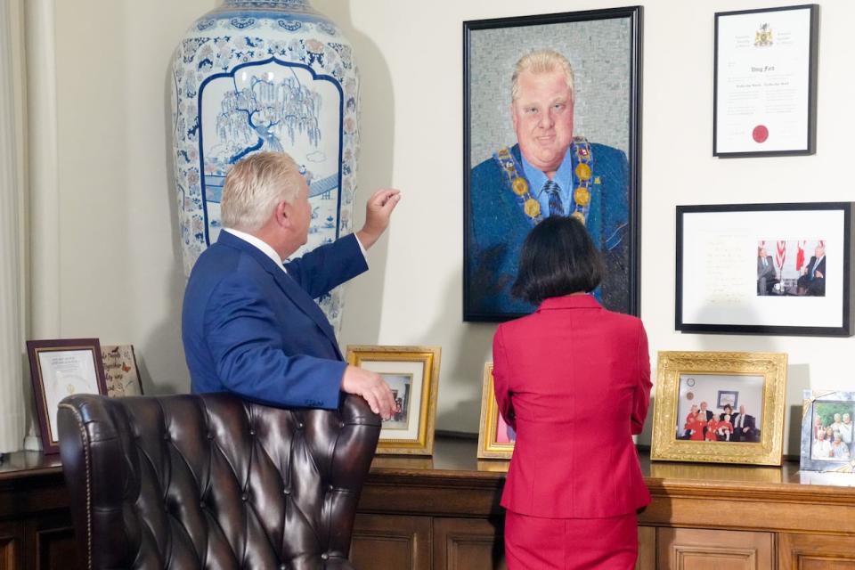 Ontario Premier Doug Ford shows a portrait of his late brother and former mayor of Toronto, Rob Ford, to Toronto's current Mayor Olivia Chow, before their meeting  at the Queen's Park Legislature in Toronto, on Monday, Sept. 18,2023. Chow has said the new deal struck between the province and City is not linked to a decision to rename a football stadium after former mayor Ford.