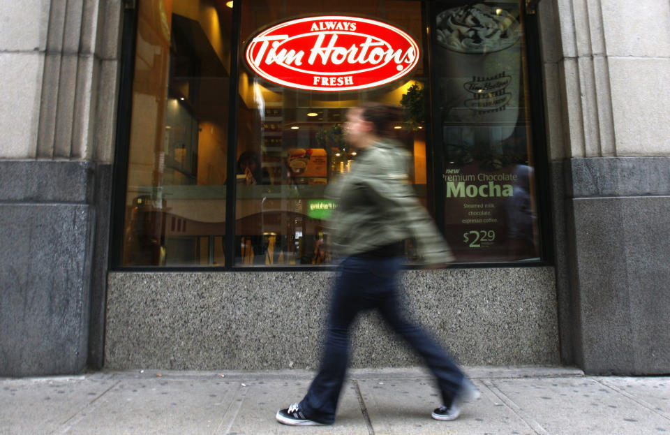 A pedestrian walks past a Tim Hortons restaurant in Toronto October 26,  2007. Profit at Tim Hortons Inc jumped 30 percent in the third quarter, the coffee and doughnut chain said, crediting higher prices, lower taxes and big sales growth.  REUTERS/Mark Blinch (CANADA)