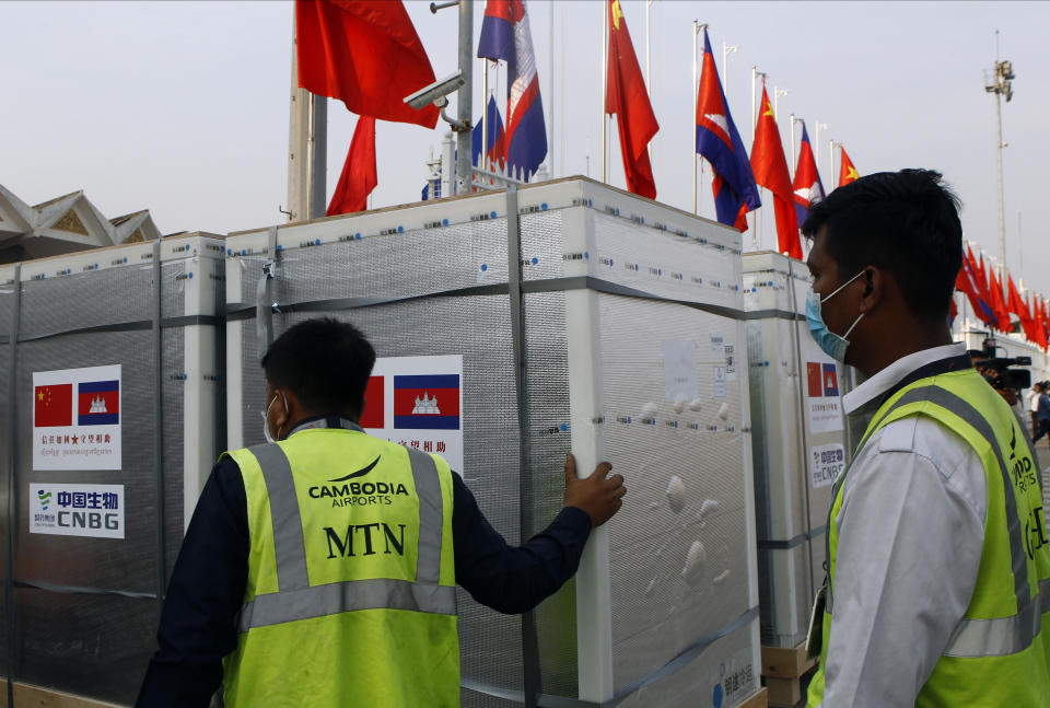 Workers pull boxes loaded with COVID-19 vaccines before a handing over ceremony at Phnom Penh International Airport, in Phnom Penh, Cambodia, Sunday, Feb. 7, 2021. Cambodia on Sunday received its first shipment of COVID-19 vaccine, a donation of 600,000 doses from China, the country's biggest ally. Beijing has been making such donations to several Southeast Asian and African nations in what has been dubbed "vaccine diplomacy," aimed especially at poorer countries like Cambodia. (AP Photo/Heng Sinith)