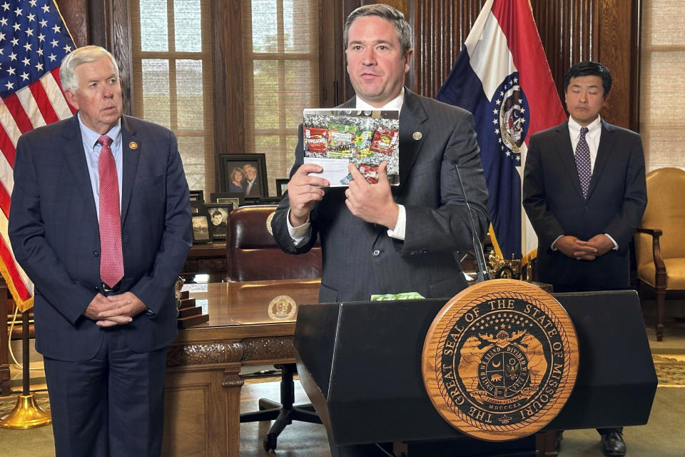 Missouri Attorney General Andrew Bailey holds up photos of candy-like products containing unregulated psychoactive cannabis ingredients that he says are being marketed to children during a press conference Tuesday, Sept. 10, 2024, at the governor's office at the state Capitol in Jefferson City, Mo. (AP Photo/David A. Lieb)