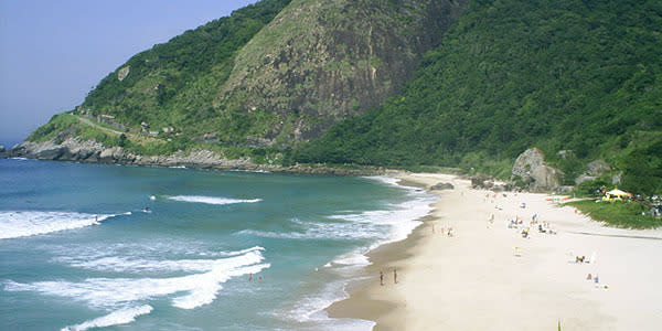 <b>Surf at Prainha Beach </b> One of the best surfing spots in Rio, Prainha Beach is a beautiful half-moon stretch of sand bordered on each side by jagged rocks and high cliffs. It takes a while to get to, but once there you’ll understand why it’s so highly regarded. For a more local experience, hop on the orange “surf bus” that passes through Copacabana.