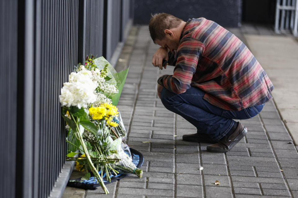 Jay Forrest pauses after placing flowers at a memorial for Charlotte Football Club soccer player Anton Walkes at Bank of America Stadium in Charlotte, N.C., Thursday, Jan. 19, 2023. Walkes died from injuries he sustained in a boat crash off the coast of Miami, authorities said Thursday. (AP Photo/Nell Redmond)