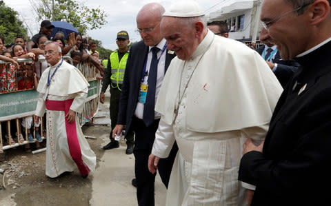 A small drop of blood stains Pope Francis' white cassock as he is helped by a priest - Credit:  Andrew Medichini/AP