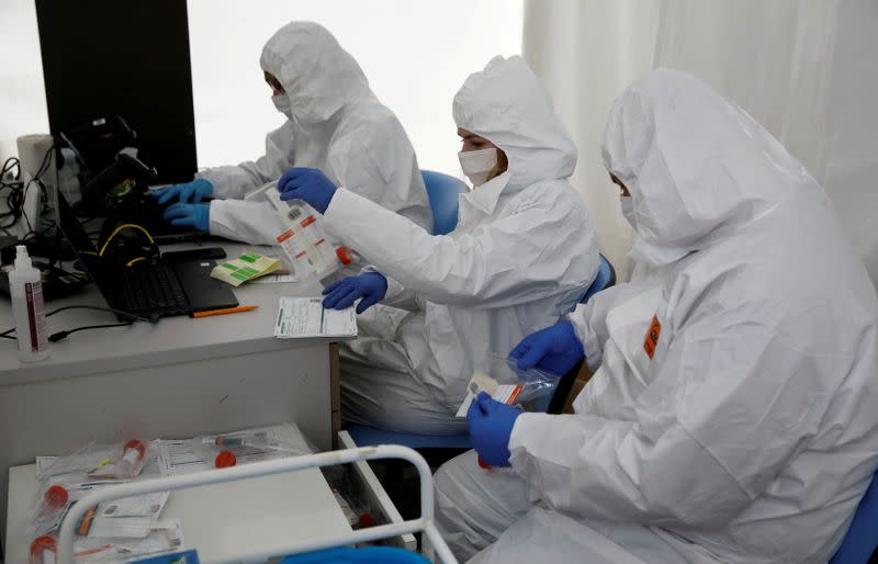 Imagen de archivo de personas vistiendo trajes de protección en un centro de exámenes por el coronavirus para personas en automóviles en Varsovia