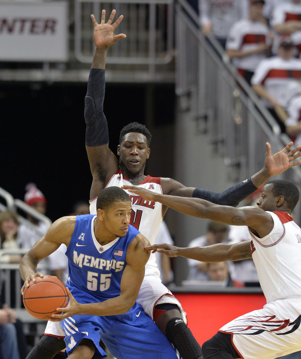 Memphis' Geron Johnson (55) looks for help against the trapping defense of Louisville's Montrezl Harrell, top, and Chris Jones, right, during the second half of an NCAA college basketball game on Thursday Jan. 9, 2014, in Louisville, Ky. Memphis defeated Louisville 73-67. (AP Photo/Timothy D. Easley)