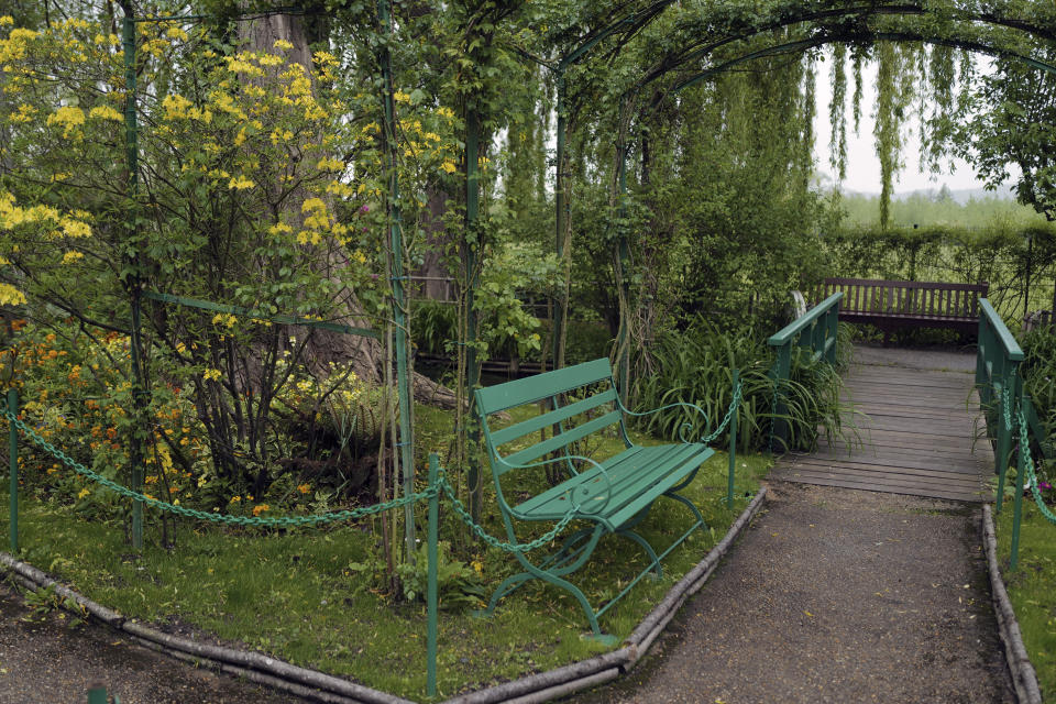 The green bench in the Japanese-inspired water garden of Claude Monet's house, French impressionist painter who lived from 1883 to 1926, waits ahead of the re-opening, in Giverny, west of Paris, Monday May 17, 2021. Lucky visitors who'll be allowed back into Claude Monet's house and gardens for the first time in over six months from Wednesday will be treated to a riot of color, with tulips, peonies, forget-me-nots and an array of other flowers all competing for attention. (AP Photo/Francois Mori)