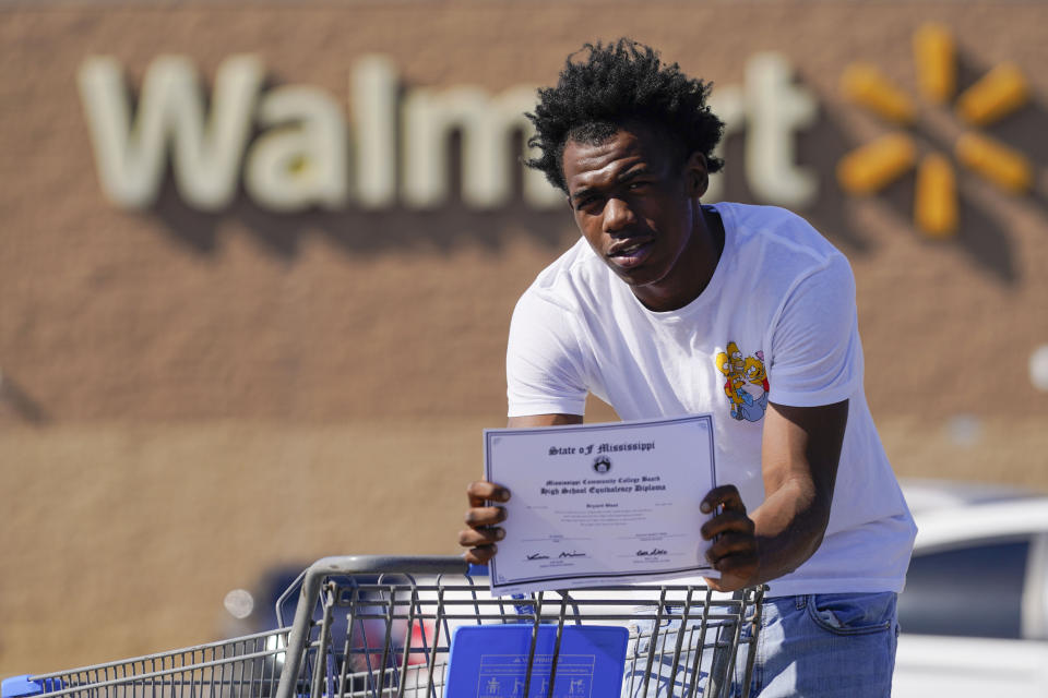 Bryant West, who has a job at a Walmart, holds a copy of his GED, as he poses for a portrait in Pascagoula, Miss., Friday, Oct. 20, 2023. Girls consistently are outperforming boys, graduating at higher rates at public high schools around the country. Students, educators and researchers say there are several reasons why boys are falling short.(AP Photo/Gerald Herbert)