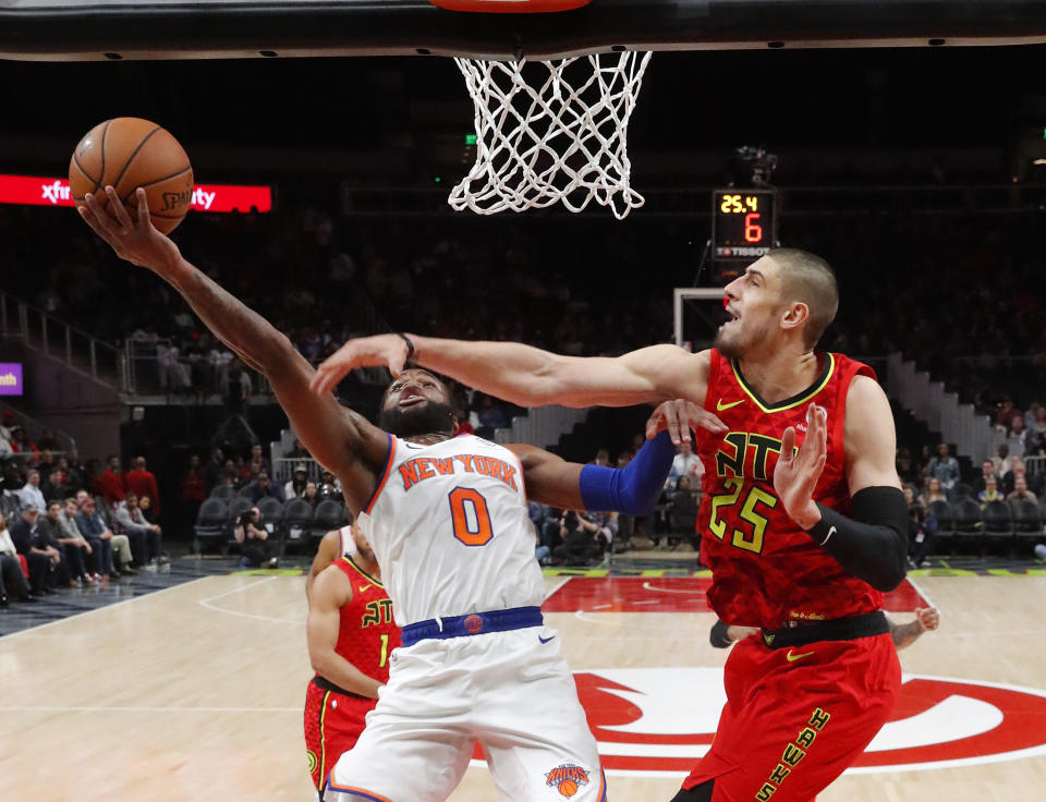 New York Knicks guard Kadeem Allen (0) gos in for a basket as Atlanta Hawks center Alex Len (25) defends during the first half of an NBA basketball game Thursday, Feb. 14, 2019, in Atlanta. (AP Photo/John Bazemore)