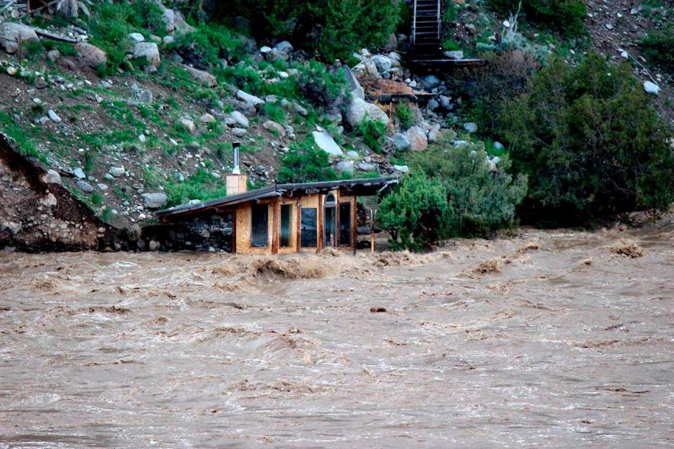 In this photo provided by Sam Glotzbach, the fast-rushing Yellowstone River flooded what appeared to be a small boathouse in Gardiner, Mont., on Monday, June 13, 2022, just north of Yellowstone National Park (AP)