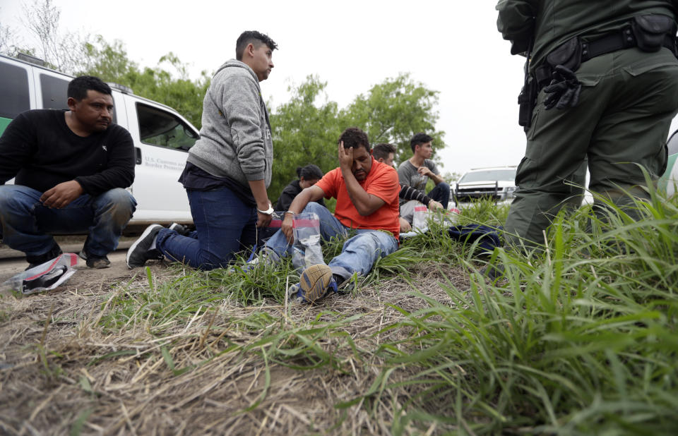 FILE - In this March 14, 2019, file photo, a Border Patrol agent talks with a group suspected of having entered the U.S. illegally near McAllen, Texas. Hundreds of thousands of people have been arriving at the border in recent months, many of them families fleeing violence and poverty in Central America. Once they reach the border, they can take different paths to try to get into the U.S. . (AP Photo/Eric Gay, File)