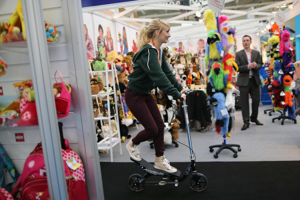 A woman rides a scooter through trade stands during the 2013 London Toy Fair at Olympia Exhibition Centre on January 22, 2013 in London, England. (Photo by Dan Kitwood/Getty Images)