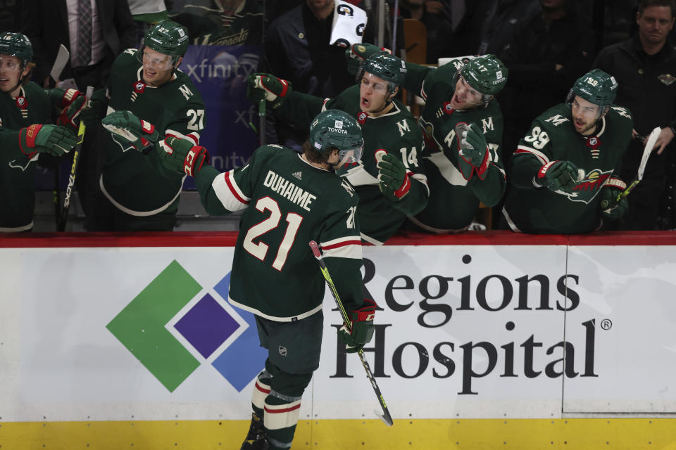 Minnesota Wild's Brandon Duhaime (21) high fives teammates on the bench after scoring a goal against the New York Islanders during the third period of an NHL hockey game Sunday, Nov. 7, 2021, in St. Paul, Minn. Minnesota won 5-2. (AP Photo/Stacy Bengs)