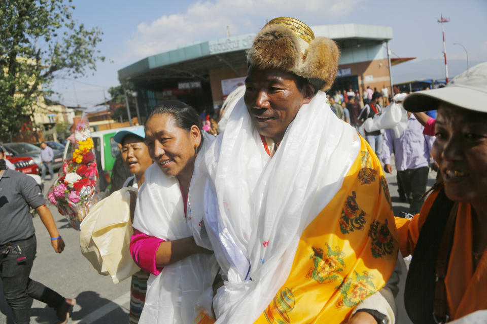 Nepalese veteran Sherpa guide Kami Rita, 49, is welcomed by his wife at the airport in Kathmandu, Nepal, Saturday, May 25, 2019. The Sherpa mountaineer extended his record for successful climbs of Mount Everest with his 24th ascent of the world's highest peak on Tuesday. (AP Photo/Niranjan Shrestha)