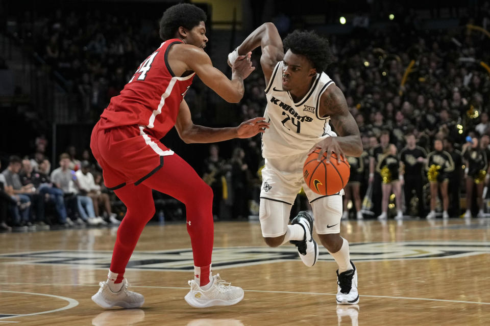 Central Florida guard Jaylin Sellers, right, drives past Texas Tech guard Kerwin Walton, left, during the second half of an NCAA college basketball game, Saturday, Feb. 24, 2024, in Orlando, Fla. (AP Photo/John Raoux)