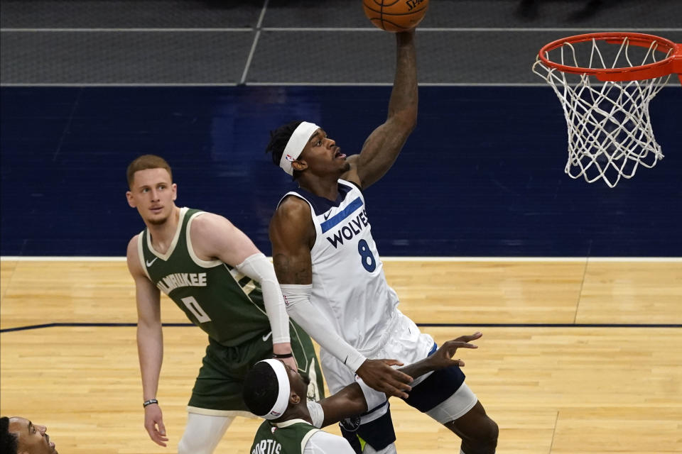 Minnesota Timberwolves' Jarred Vanderbilt (8) lays up a shot in front of Milwaukee Bucks' Donte DiVincenzo (0) in the first half of an NBA basketball game Wednesday, April 14, 2021, in Minneapolis. (AP Photo/Jim Mone)