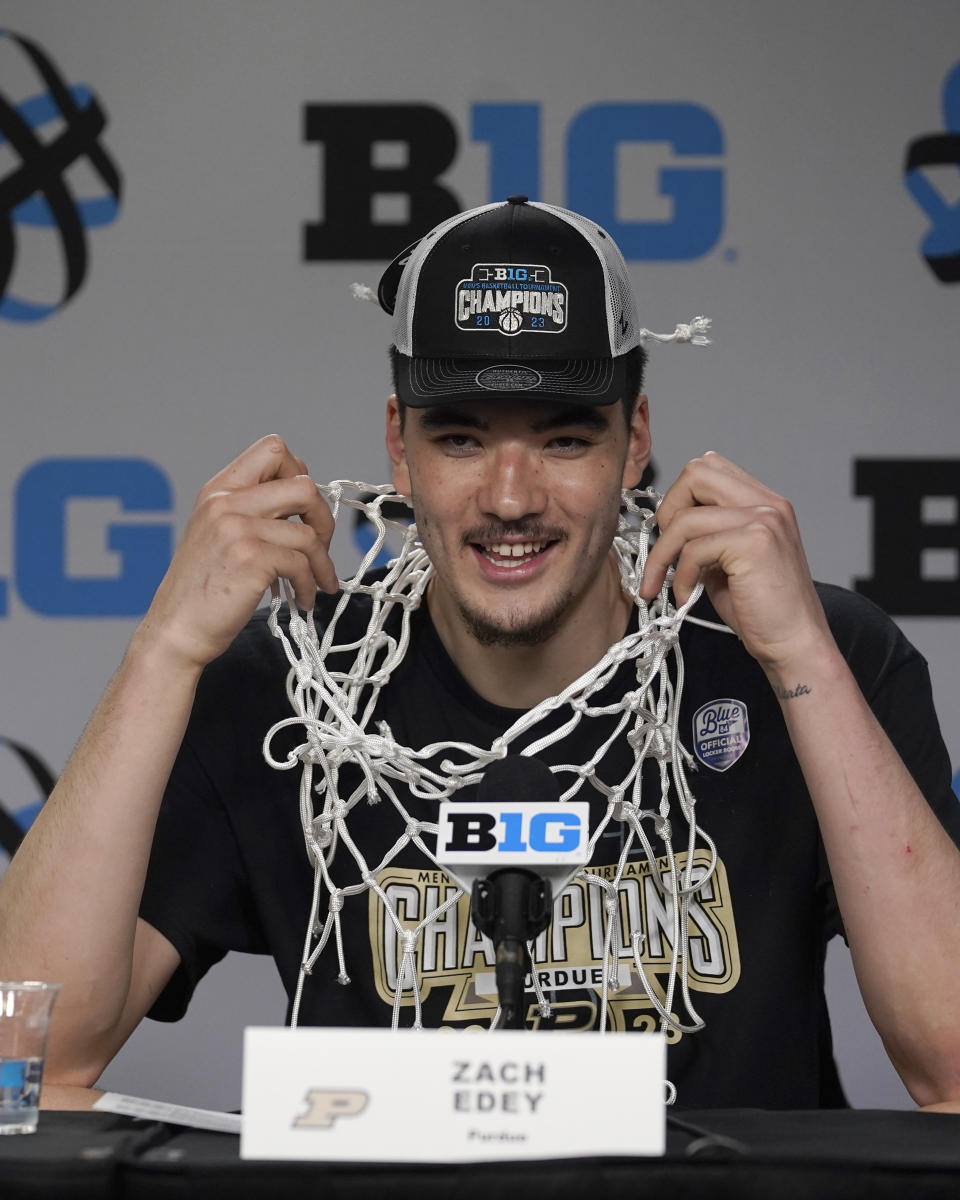 Purdue's Zach Edey smiles as he wears the net around his neck as he arrives for a news conference after his team's 67-65 win over Penn State to claim the Big Ten tournament championship in an NCAA college basketball game Sunday, March 12, 2023, in Chicago. (AP Photo/Erin Hooley)