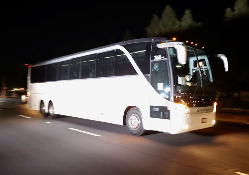 A bus carrying quarantined passengers from the Grand Princess cruise ship drives onto Travis Air Force Base in Fairfield