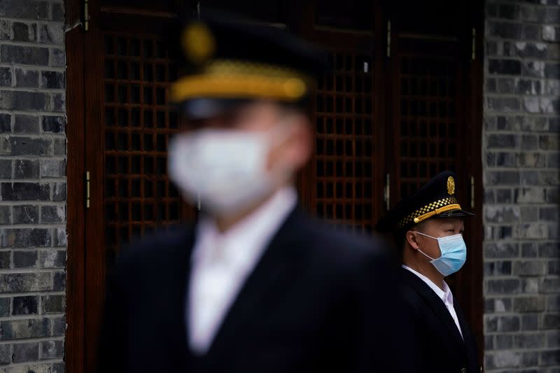 Security guards wearing face masks are seen in Wuhan