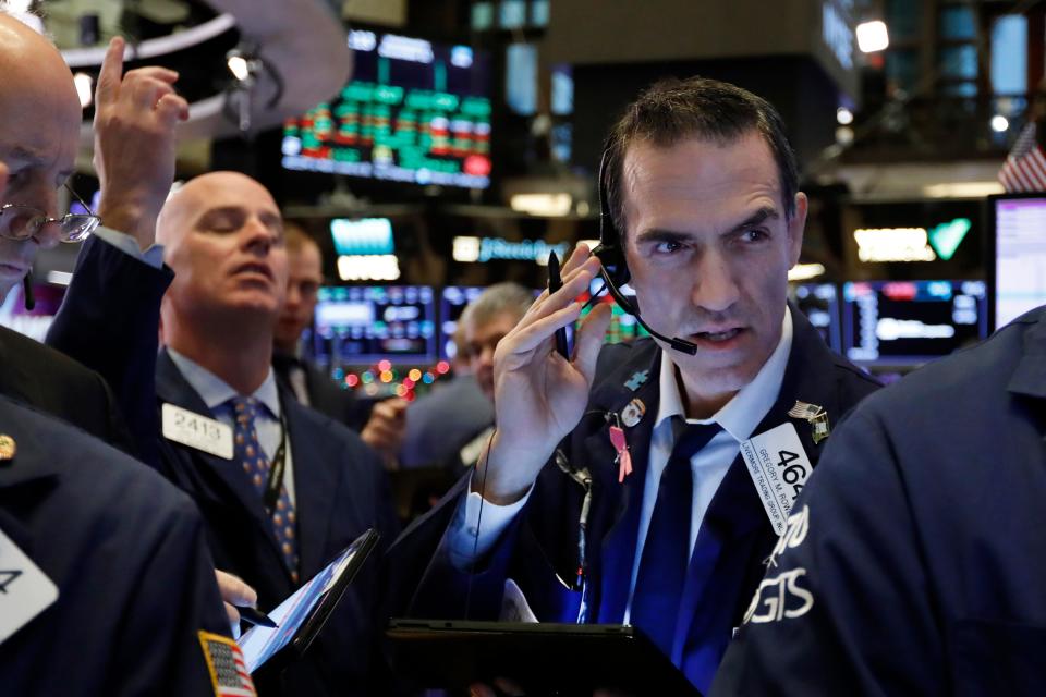 Trader Gregory Rowe, right, works on the floor of the New York Stock Exchange, Wednesday, Dec. 11, 2019.