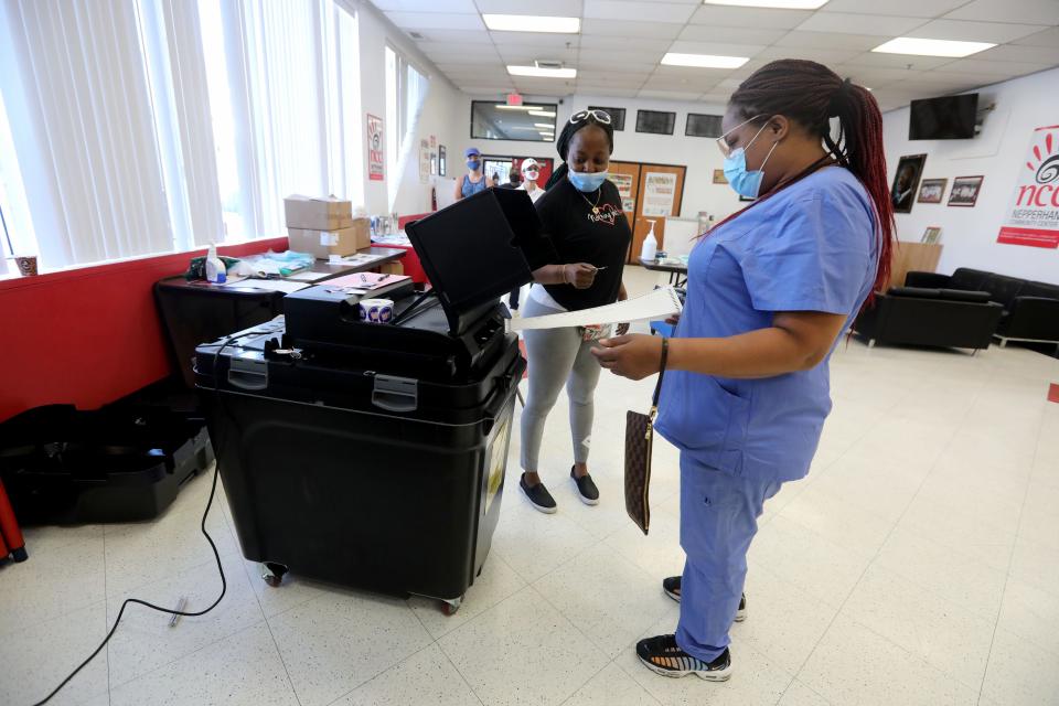 LaShawn Frazier places her ballot into a scanner as she votes in primary elections at the Nepperhan Community Center in Yonkers on June 23, 2020.