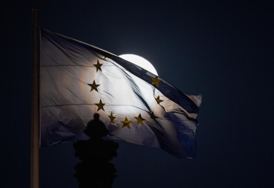 Der Mond geht als sogenannter Supermond auf, im Vordergrund ist eine EU-Flagge auf dem Reichstagsgebäude zu sehen. Stehe der Mond - wie am Dienstagabend - im Perigäum, sei die Fläche der sichtbaren Mondscheibe um 30 Prozent größer als bei einem Vollmond im Apogäum. (Foto: Christophe Gateau/dpa)