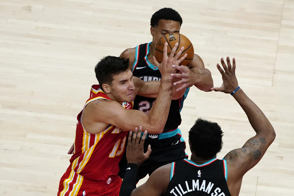 Atlanta Hawks guard Bogdan Bogdanovic (13) is defended by Memphis Grizzlies guard Desmond Bane (22) as he tries to shoot in the first half of an NBA basketball game Wednesday, April 7, 2021, in Atlanta. (AP Photo/John Bazemore)