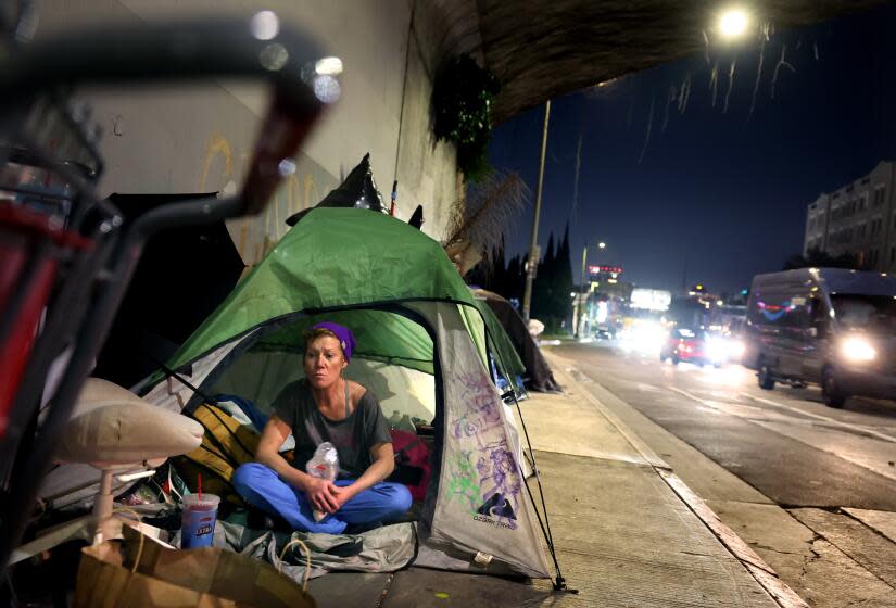 Hollywood, California February 22, 2024-Jovette Cutaiar, 49, who has been homeless for five years, eats marshmallows at a homeless encampment under the 101 freeway on Cahuenga Blvd. in Hollywood. (Wally Skalij/Los Angeles Times)