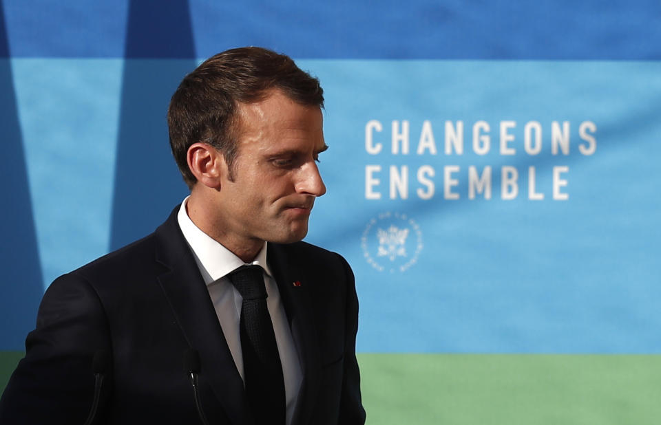 French President Emmanuel Macron leaves after delivering a speech on 'The presentation of the strategy for ecology transition', at the Elysee Palace in Paris, Tuesday, Nov. 27 2018. Macron said the government will find a way to delay tax increases on fuel during periods when world oil prices are rising. The move aims to reproduce the situation that has led to protests in recent days, some of which have become violent and even marred the famed Champs-Elysees avenue in central Paris. Behind reads: Change together. (Ian Langsdon, Pool via AP)