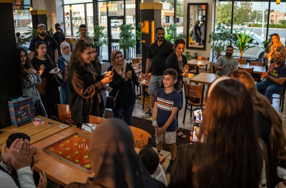 Saleh Humaid, 8, of Gaza, center, talks with community members affiliated with the Palestine Children's Relief Fund's Detroit chapter who had interactions with Saleh after they sang him "Happy Birthday" during his going-away party at Masri Sweets in Dearborn on Tuesday Aug. 8, 2023. Even though his birthday is in September, Palestine Children's Relief Fund Detroit chapter president Yasmeen Hamed wanted to give him his first birthday party before he left to go back home.