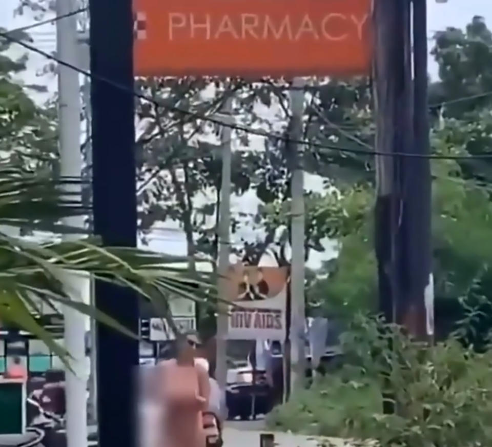 Pic Shows: Naked tourist crossing street In Bali;  Outraged Balinese authorities are trying to track down two female tourists after one of them was filmed brazenly crossing a street while totally naked.