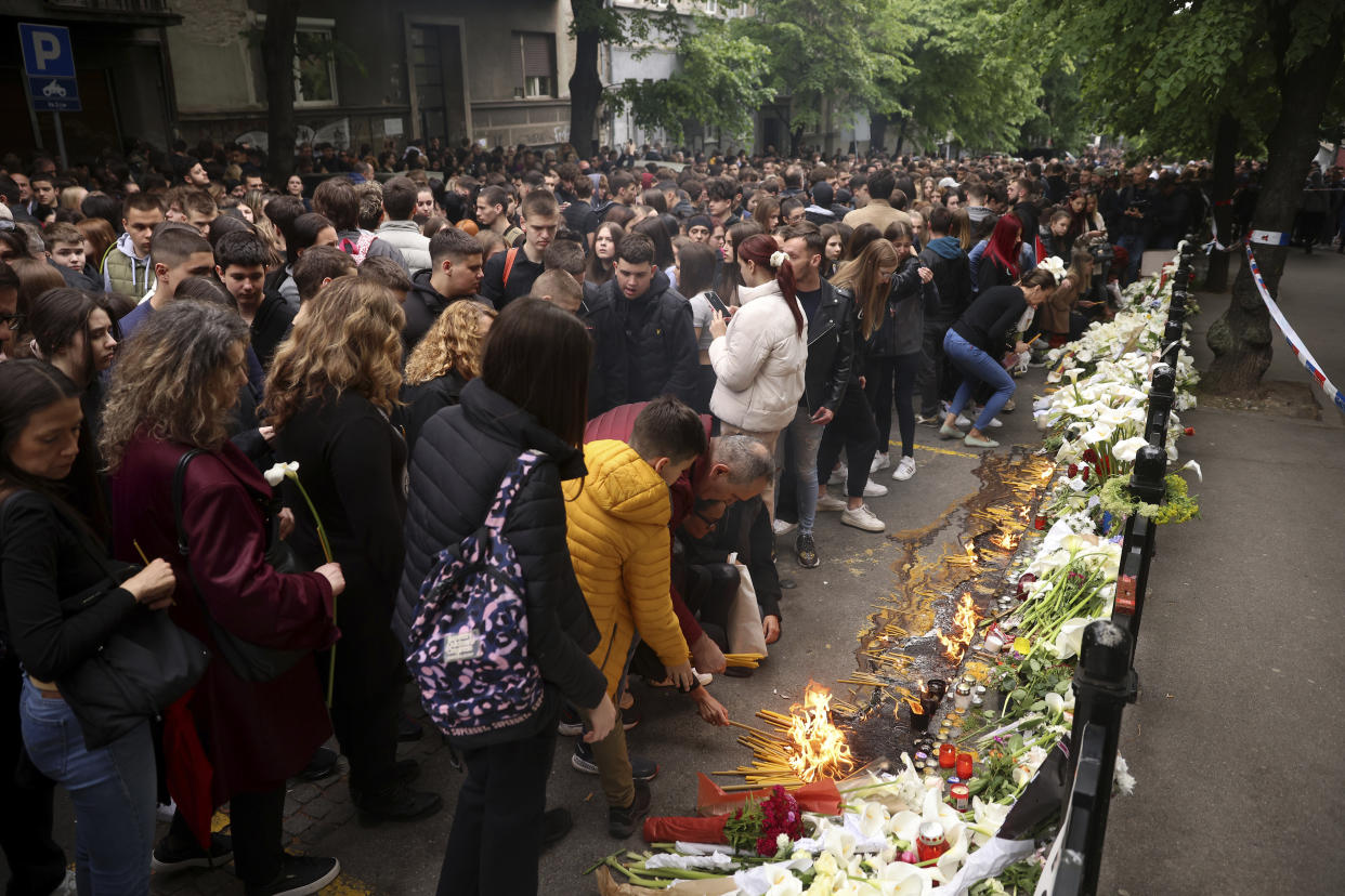 School children gather to light candles for the victims near the Vladislav Ribnikar school in Belgrade, Serbia, Thursday, May 4, 2023. Many wearing black and carrying flowers, scores of Serbian students on Thursday paid silent homage to their peers killed a day earlier when a 13-year-old boy used his father’s guns in a school shooting rampage that sent shock waves through the nation and triggered moves to boost gun control. (AP Photo/Armin Durgut)