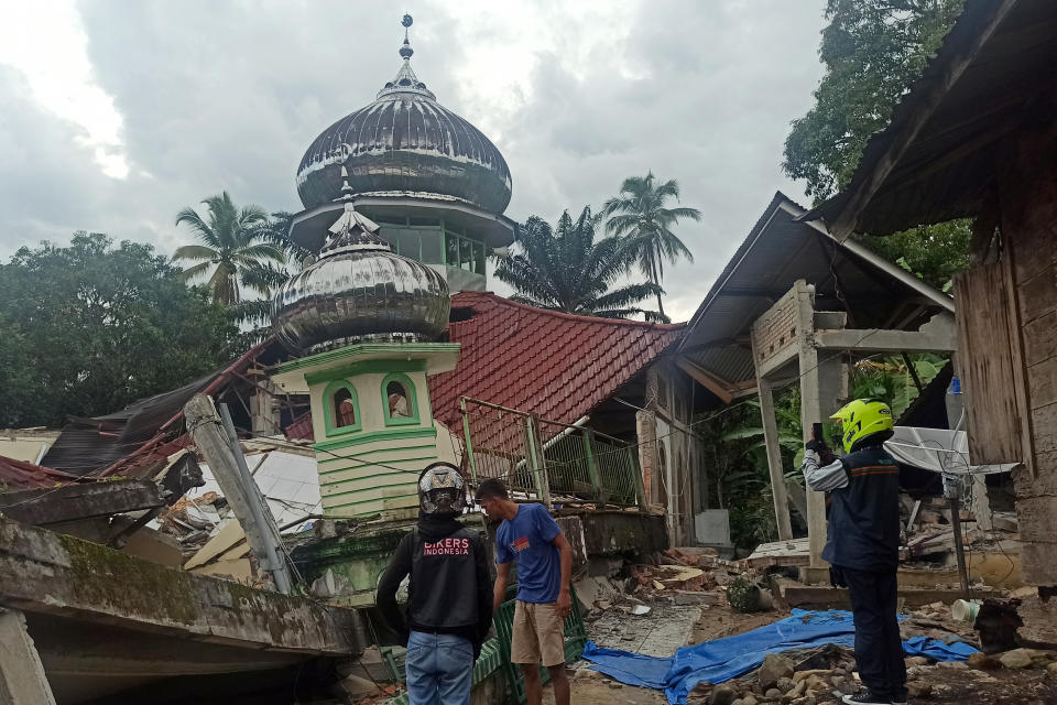 People inspect a damaged mosque following an earthquake in Pasaman, West Sumatra, Indonesia, Friday, Feb. 25, 2022. The strong and shallow earthquake hit off the coast of Indonesia's Sumatra island on Friday, panicking people in Sumatra island and neighboring Malaysia and Singapore. (AP Photo/Marsulai)