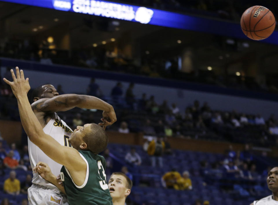 Wichita State forward Chadrack Lufile (0) blocks a shot by Cal Poly forward Chris Eversley (33) during the first half of a second-round game in the NCAA college basketball tournament Friday, March 21, 2014, in St. Louis. (AP Photo/Jeff Roberson)