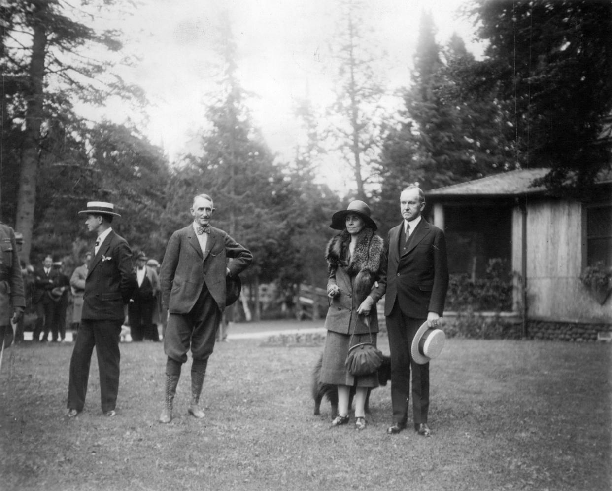 President Calvin Coolidge (right, with wife Grace Coolidge) stop for a photo at Cedar Island Lodge in Brule, Wisconsin. In 1928, Coolidge made the Douglas County resort his Summer White House.