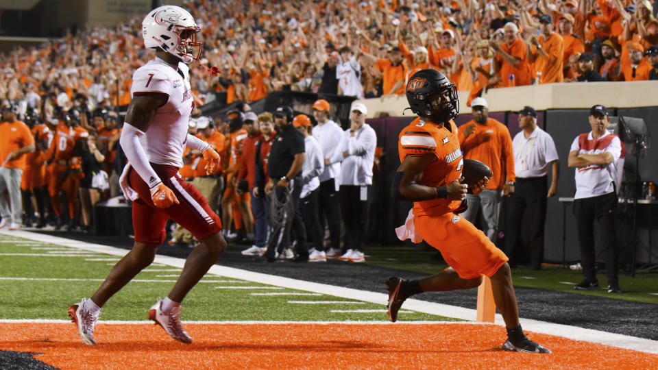 Oklahoma State running back Jaden Nixon (3) scores a touchdown as South Alabama Jaguars safety Jalen Jordan (1) trails during the second half of an NCAA college football game Saturday, Sept. 16, 2023, in Stillwater, Okla. (AP Photo/Brody Schmidt)