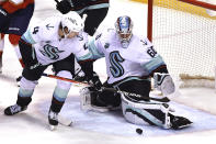 Seattle Kraken goaltender Chris Driedger (60) makes a save against the Florida Panthers next to defenseman Haydn Fleury (4) during the second period of an NHL hockey game Saturday, Nov. 27, 2021, in Sunrise, Fla. (AP Photo/Jim Rassol)