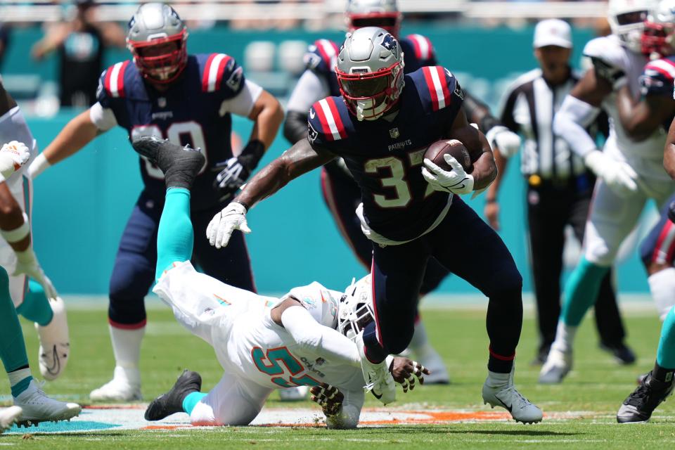 Sep 11, 2022; Miami Gardens, Florida, USA; New England Patriots running back Damien Harris (37) breaks the tackle of Miami Dolphins linebacker Jerome Baker (55) during the first half at Hard Rock Stadium. Mandatory Credit: Jasen Vinlove-USA TODAY Sports