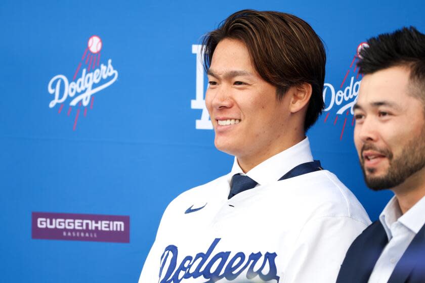 Pitcher Yoshinobu Yamamoto smiles during a news conference at Dodger Stadium